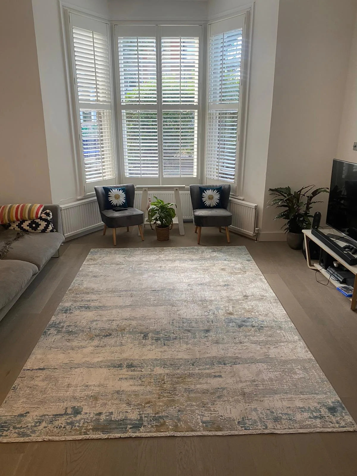 Customer's bamboo silk rug in a bright bay-window living room
